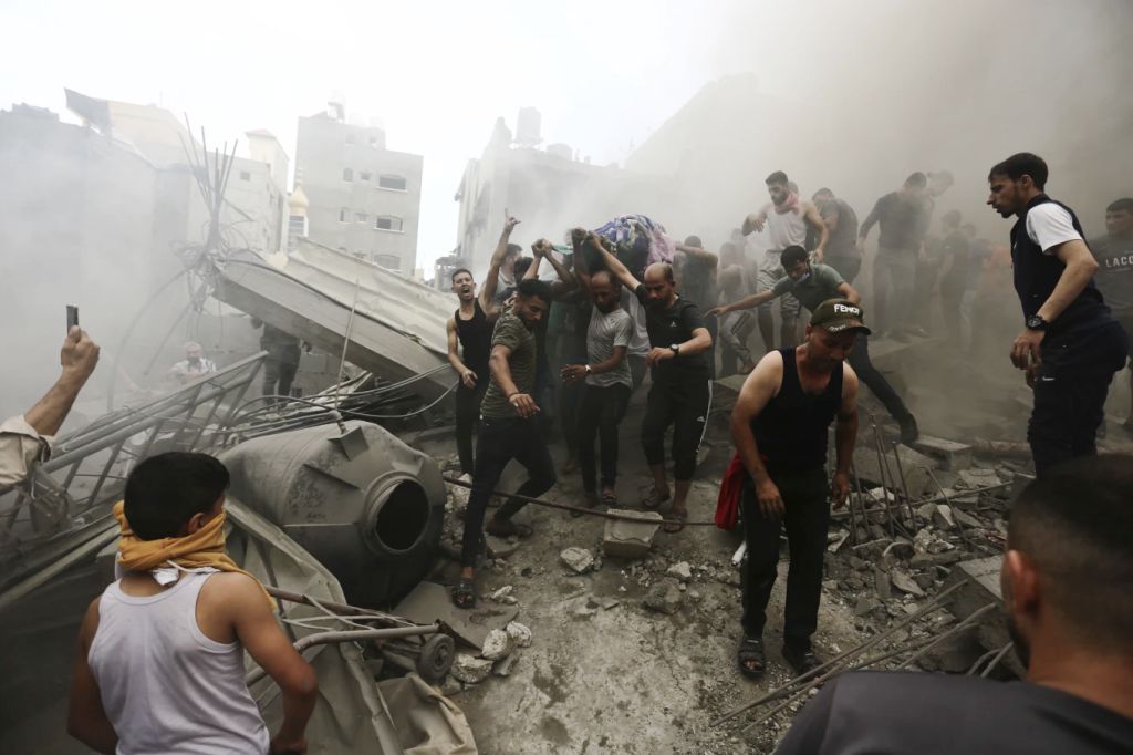 Palestinians removing a dead body from a building rubble after Israeli airstrike Jebaliya refugee camp in Gaza Strip - Source AP Photo-Ramez Mahmoud