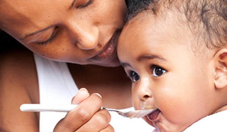 A mother feeding her infant Cerelac baby food - Image Source - Nestle